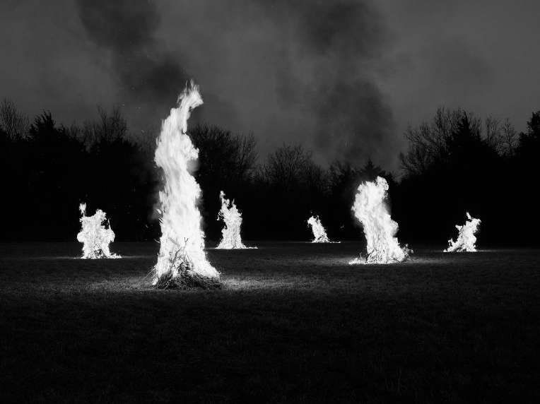 Black and white image of multiple bonfires